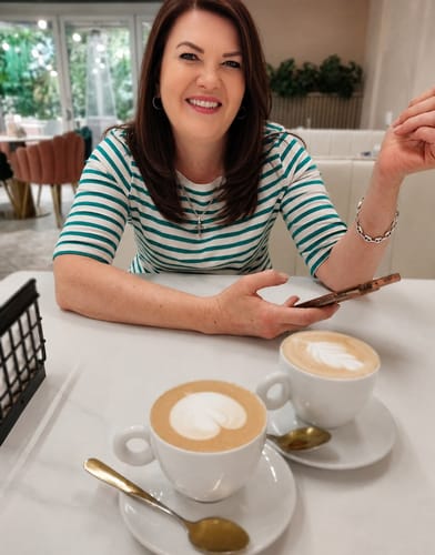 Customer's smooth, dark hair after using Redken Extreme Shampoo while sitting at a table with coffee.