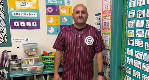 Customer wearing a maroon and white striped baseball jersey with a Cubs logo in a classroom.