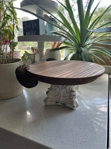 Customer's Lawrence French Provincial Cake Stand with a natural wood top and ornate white pedestal on a kitchen counter.