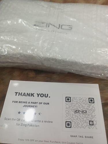 Customer's OUD Supreme BUNDLE packaging with a thank you card and QR code on a wooden surface.
