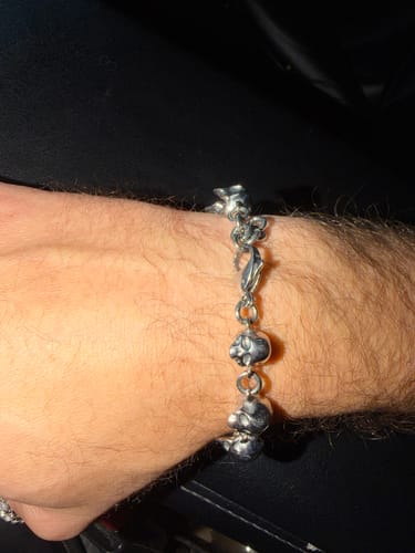 Customer's 10 Stages of Addiction bracelet featuring silver skull links, worn on a wrist.