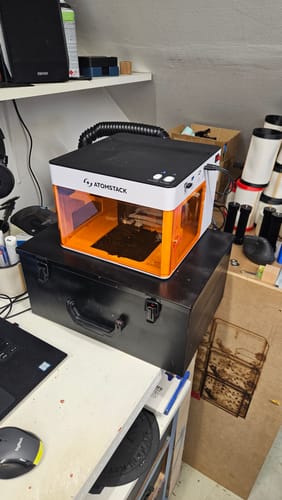 Customer's AtomStack P1 Laser Engraver sitting on a black case on an office desk