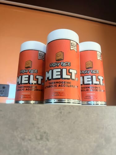 Customer's three orange containers of UGLYFACE MELT supplement standing on a counter.