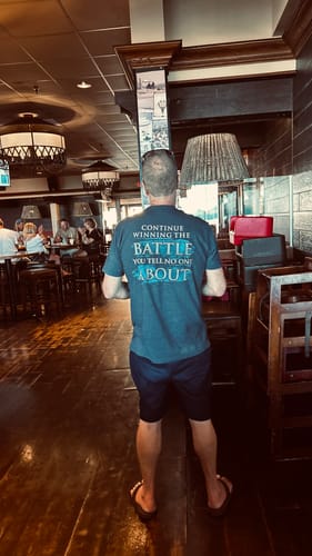 Customer's T.V.P. Elite Membership shirt being worn, showing the back message in a restaurant.