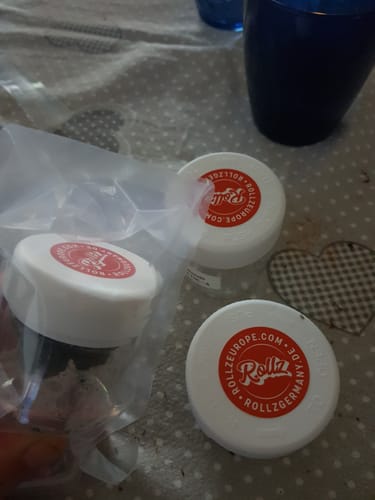 Customer's Lemonatti THC-A flower containers and a plastic-wrapped pack on a patterned surface