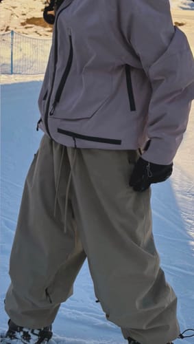 Customer's pink snow jacket worn by a person on a snowy slope.