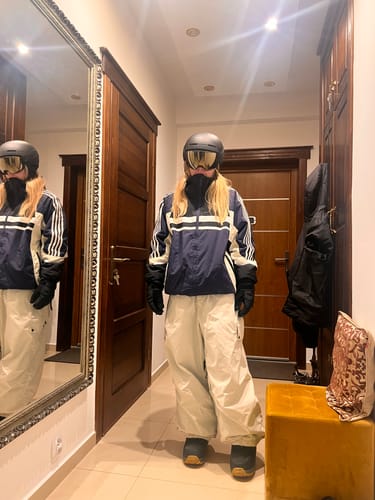 Reviewer standing in a hallway wearing the navy and white Women's Retro Sporty Stripes Trim Colorblock Snow Jacket.