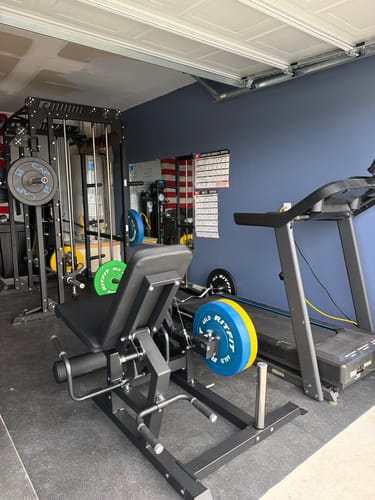 Customer's black RitFit Mustang PRO Leg Extension Curl Machine in a home garage gym setup