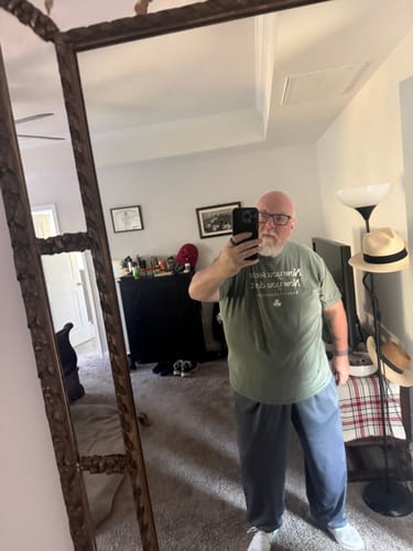 Reviewer in a bedroom mirror selfie, wearing the sage green Irish Goodbye See Me T-Shirt.