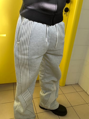 Customer's gray Jogging Archive sweatpants with side stripes, worn in a baggy fit with dark shoes.