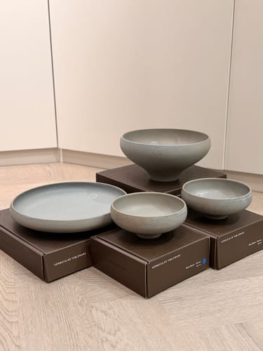 Customer's Vermicular Tableware set with grey bowls and a plate arranged on their product boxes.