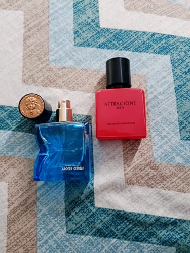 Customer's Kit Adonis Citrus + Attracione Men perfumes, one blue bottle with gold cap and one red bottle on patterned surface.