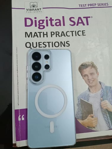 Customer's clear phone case with a circular magnetic ring on the back, resting on a study book.