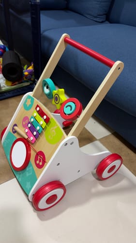 Customer's Hape My First Musical Walker featuring a xylophone, drum, and wooden frame, sitting on a floor.