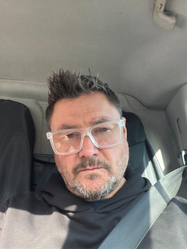 Customer's clear, large frame reading glasses being worn while sitting in a car.