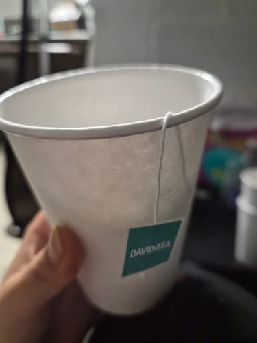 Customer's Cold 911 Organic tea bag tag hanging from a white paper cup