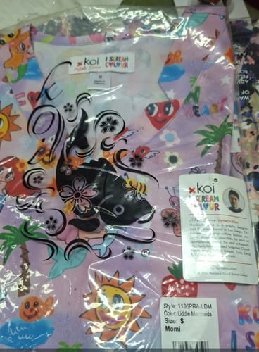Customer's Koi 1136PRA top in plastic packaging, featuring a colorful mermaid and heart pattern.