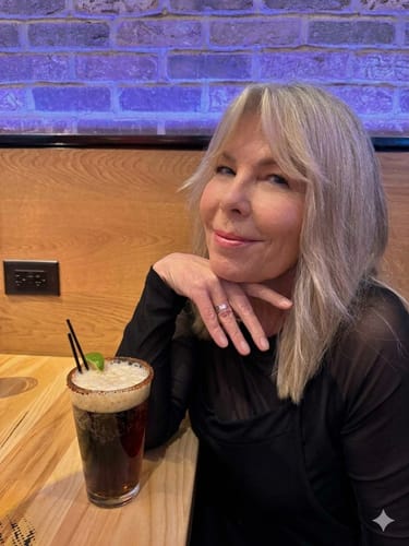 Reviewer wearing a black Brigitte Brianna Move Jumper while smiling at a table with a drink.
