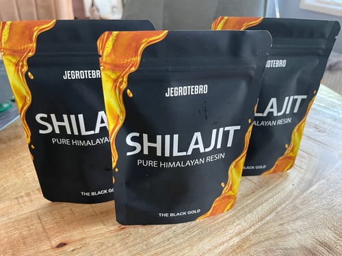 Klantfoto van drie Shilajit-verpakkingen op een houten oppervlak