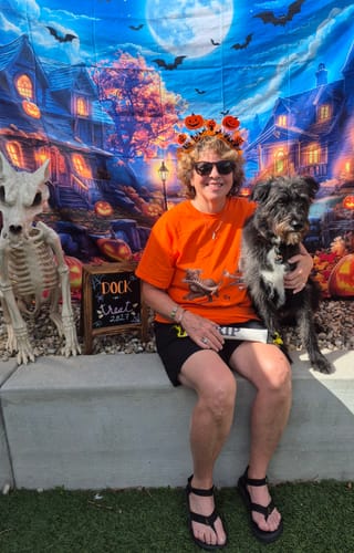 Customer's orange personalized shirt featuring a dog design, worn while holding their dog at an event.