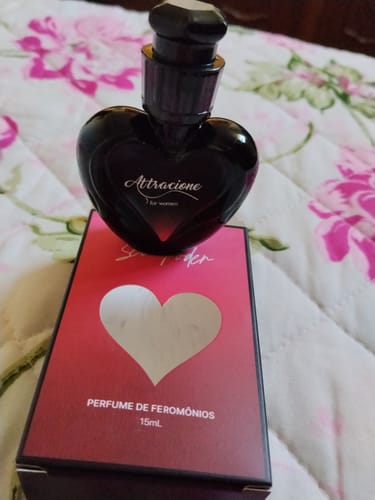 Customer's Attracione Sensual perfume bottle in a black heart shape sitting on top of its red and black packaging.