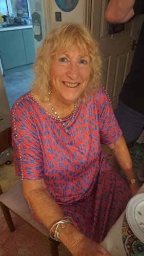 Smiling woman with blonde hair at home, customer photo