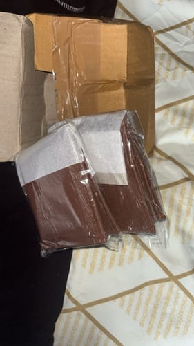 Customer's ZIORO Spiderman wallet inside opened shipping box, wrapped in protective plastic film.