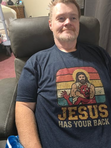Reviewer wearing a dark navy Jesus Has Your Back T-Shirt with a graphic of Jesus wrestling a demon.