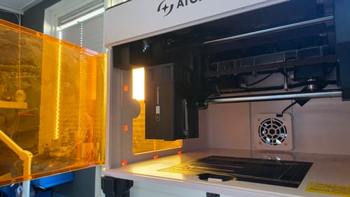 Customer's AtomStack P1 Laser Engraver with the orange safety door open, revealing the laser head inside.