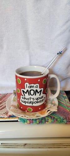 Customer's Organic Earl Grey tea in a red, polka-dotted mug with a glass straw on a saucer.