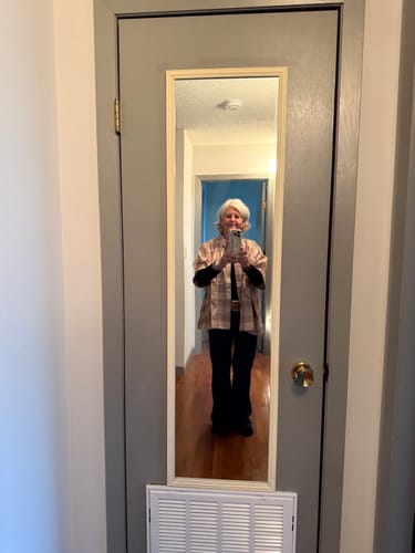 Customer's red and tan plaid dolman sleeve top worn with dark pants while looking in a mirror