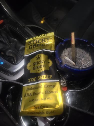 Customer's Colombia Gold Pre Rolls in a gold package next to a blue ashtray containing used pre rolls.
