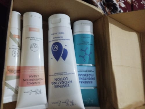 Customer's 24 Hour Glow Pack skincare bottles sitting inside an open cardboard delivery box.