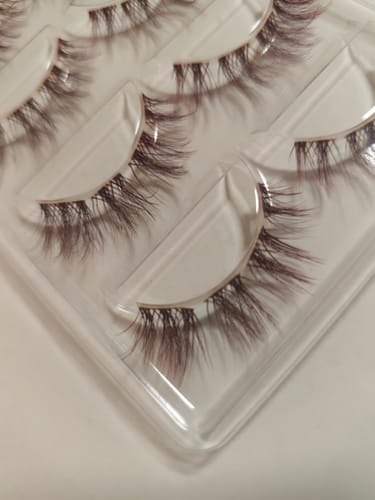 Reviewer's THE MANGA EYE BURGUNDY lashes in a clear plastic tray, showing the spiked, deep-red design.