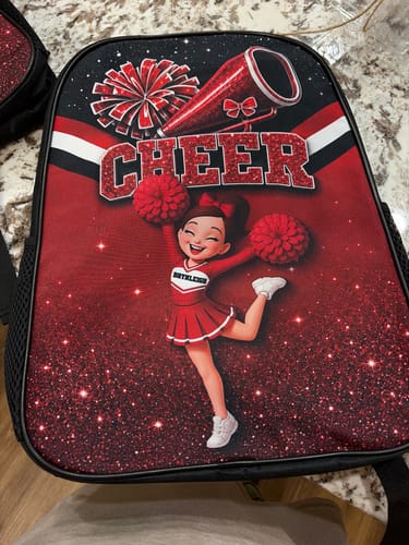 Customer's personalized Cheerleader Girl backpack in red and black with cheerleader graphic and pom-poms.