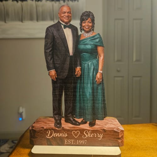 Customer's custom wooden portrait plaque of a couple, personalized with names and date, standing on a display base.