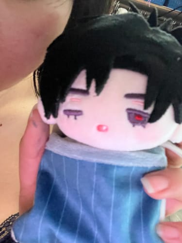 Customer's Alien Stage Dreaming Hours plush pendant being held, showing a black-haired character in a blue striped suit.