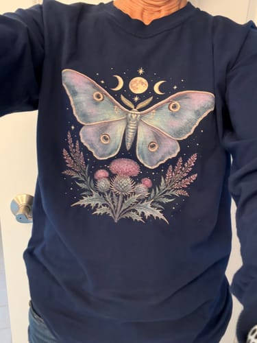 Customer's navy long sleeve Emperor Moth Thistle Bouquet shirt with moth and floral graphic print.