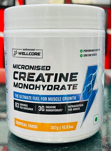 Reviewer's Wellcore Micronised Creatine Monohydrate tub showing Tropical Tango flavor and product details.