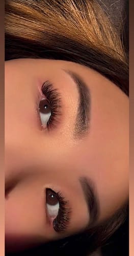 Customer's Infinaluxe Pre-mapped Segment Lash Extensions on eyes, showing wispy, dark lashes in a close-up.