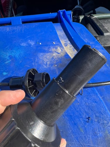 Reviewer's hand holding a detached black Ripper Cap nozzle, showing a close-up of the plastic part.