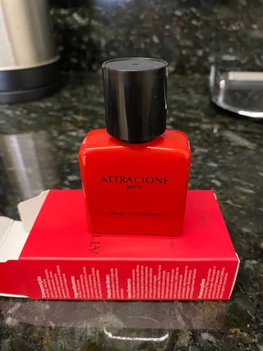 Customer's Attracione Men pheromone perfume bottle in bright red resting on its matching red product box.