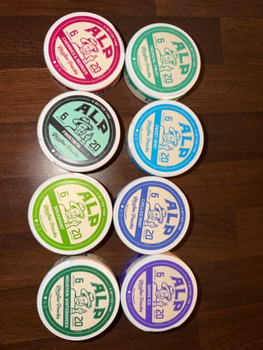 Customer's collection of eight colorful ALP nicotine pouch tins, featuring various fruit and mint flavors.