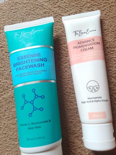 Reviewer's Essense Brightening Facewash and Advance Pigmentation Cream tubes on a textured surface.
