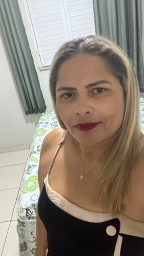 Customer's photo in a bedroom setting, possibly reviewing the Perfume Attracione Sensual.