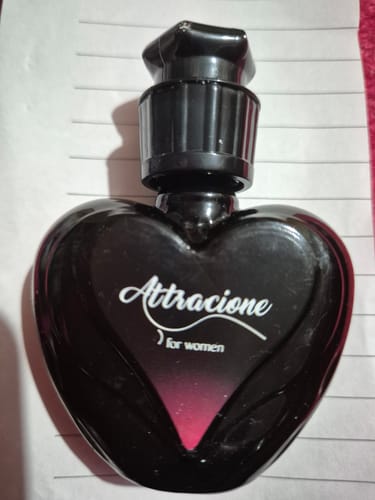 Reviewer's Perfume Attracione Sensual in a black, heart-shaped glass bottle with a black cap.
