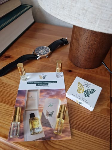 Customer's Tester Set with small perfume vials, a product card, and a white box on a wooden desk.