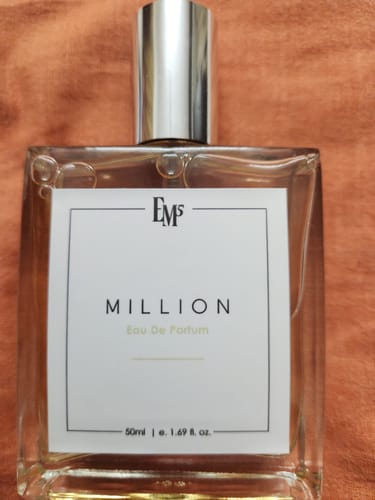 Customer's glass Million Eau De Parfum bottle featuring a white rectangular label against a textured orange background