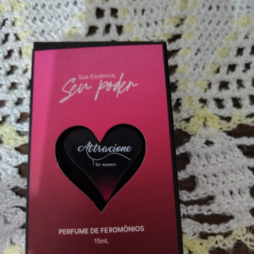Reviewer's Perfume Attracione Sensual box in vibrant pink and black featuring a heart cutout design.