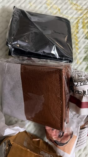 Customer's Spiderman wallet, partially wrapped in plastic inside shipping packaging.